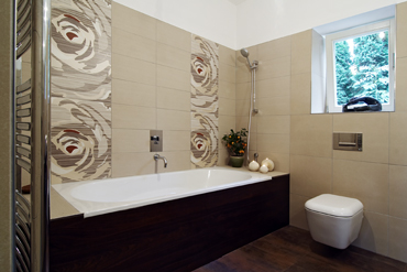Vana v koupelně má podezdívku obloženou dřevem, keramické obklady jsou s orientálním motivem