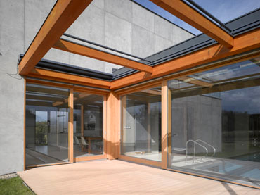 Detail terasy - v dřevěné pergole z lepených trámů je skrytá el. zatahovací látková markýza, která chrání před sluncem a deštěm, terasa propojuje vnitřní prostor domu se zahradou